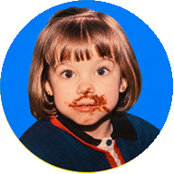 Una niña con la cara manchada de tarta, disfrutando el bocado